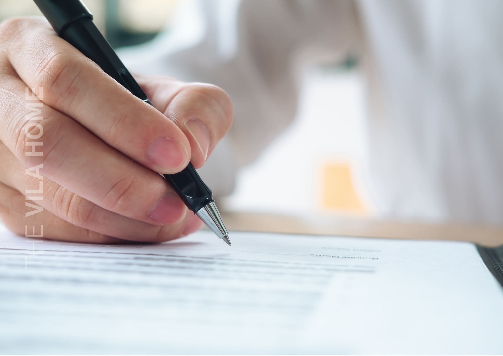 Persona firmando la hoja de firmas en visitas inmobiliarias con un agente inmobiliario en The Vila Home